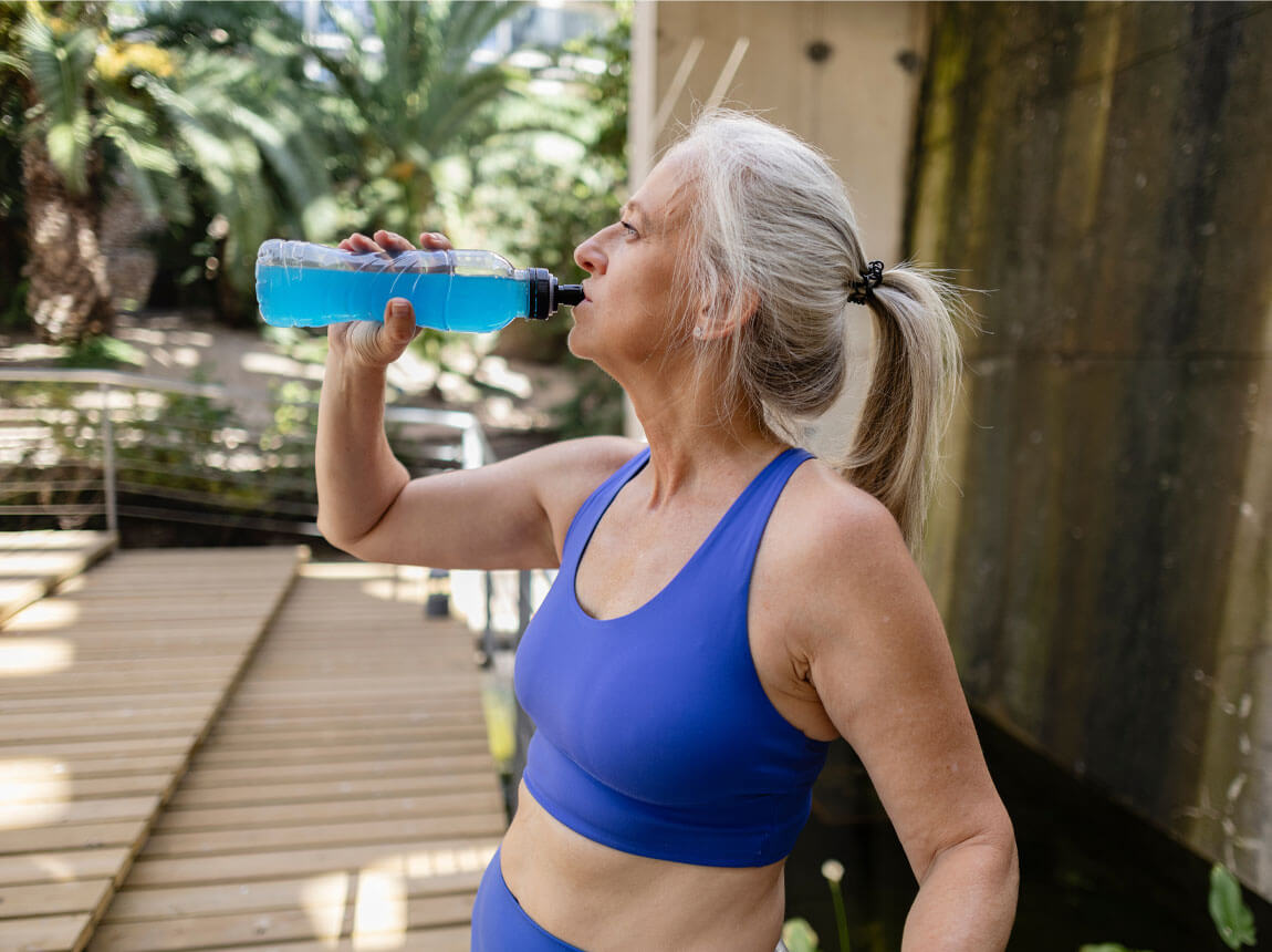 staršia, aktívna žena s izotonickým nápojom