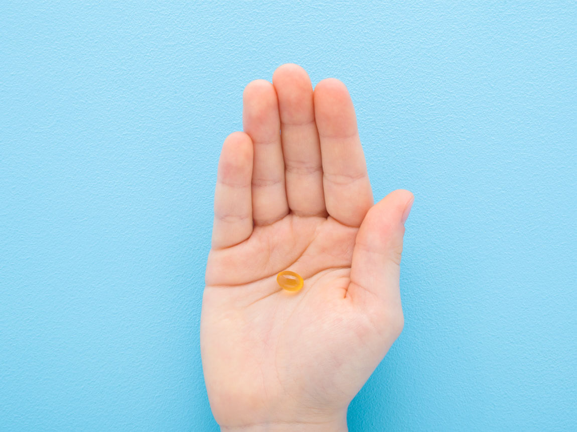 detská ruka – vitamín D3 v gélovej kapsule